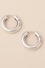 Load image into Gallery viewer, Pair of silver hoop earrings on a beige background