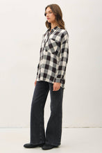 Load image into Gallery viewer, Woman wearing a black and white checkered shirt and dark jeans on a white background