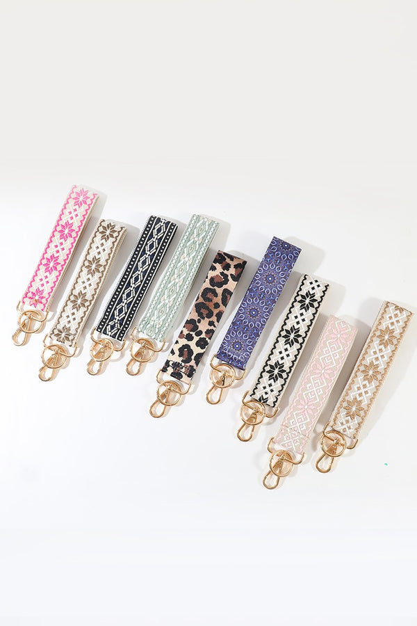 Set of nine colorful phone strap accessories with various patterns on a white background