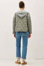Load image into Gallery viewer, Person wearing a quilted jacket and blue jeans on a white background