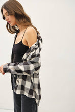 Load image into Gallery viewer, Woman wearing a black and white checkered shirt over a black top on a white background