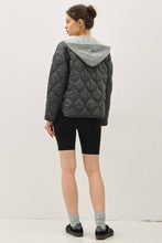 Load image into Gallery viewer, Person wearing a quilted jacket with a gray hood on a white background