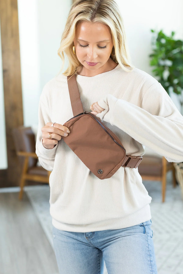 girl in white top with brown bum bag