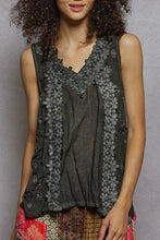 Load image into Gallery viewer, Woman wearing a sleeveless floral top over a gray shirt with colorful pants against a gray background