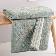 Load image into Gallery viewer, Floral-patterned quilt on a wooden table with a light background