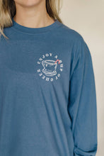 Load image into Gallery viewer, Blue long-sleeve shirt with a graphic design on a beige background