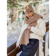 Load image into Gallery viewer, Woman in winter clothing with a scarf and headband standing in a snowy area.