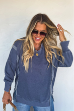 Load image into Gallery viewer, Woman wearing a blue sweater and sunglasses against a white wall