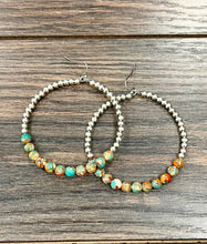 Load image into Gallery viewer, Pair of beaded hoop earrings on a wooden surface