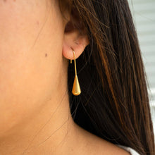 Load image into Gallery viewer, Close-up of a person wearing a gold teardrop earring.