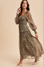 Load image into Gallery viewer, Woman wearing a long, patterned dress against a beige background