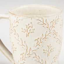 Load image into Gallery viewer, White ceramic mug with subtle leaf pattern on a light gray background
