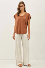 Load image into Gallery viewer, Woman wearing a brown top and white pants on a white background