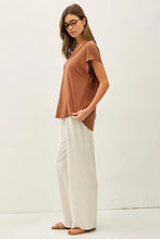 Load image into Gallery viewer, Woman wearing a brown top and white pants on a white background