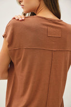Load image into Gallery viewer, Brown t-shirt with a patch on a plain background