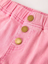 Load image into Gallery viewer, Close-up of pink shorts with gold buttons on a light background