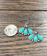Load image into Gallery viewer, Turquoise teardrop earrings with silver accents on a wooden surface next to a quarter for scale.