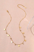 Load image into Gallery viewer, Gold necklace with small pendants on a pink background