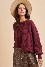 Load image into Gallery viewer, Woman wearing a maroon cable knit sweater and beige hat against a beige background