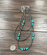 Load image into Gallery viewer, Necklace with turquoise beads on a wooden surface
