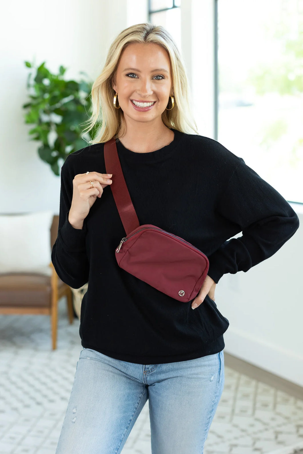 girl wearing black sweater and burgundy bum bag crossbody