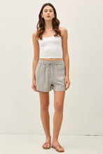 Load image into Gallery viewer, Woman wearing a white top and striped shorts on a plain background