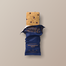 Load image into Gallery viewer, Maple blueberry muffin protein bar with blue wrapper on a beige background