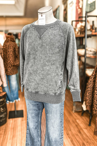Gray sweatshirt on a mannequin with leopard print accents in a store setting