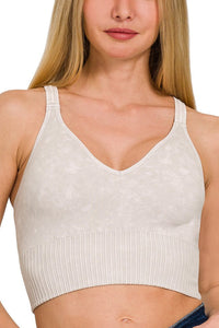 Woman wearing a beige ribbed tank top on a white background
