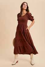 Load image into Gallery viewer, Woman wearing a brown dress with puffed sleeves on a beige background