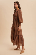 Load image into Gallery viewer, Woman wearing a brown patterned dress on a beige background