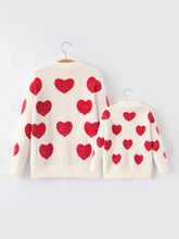 Load image into Gallery viewer, Two cream-colored sweaters with red heart patterns on a white background