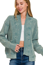Load image into Gallery viewer, Woman wearing a textured green jacket with a white top and blue jeans on a white background