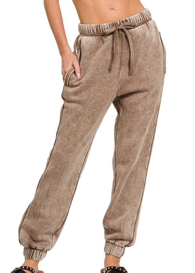 Mocha-colored sweatpants worn by a person on a white background