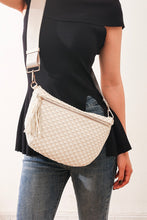 Load image into Gallery viewer, Person wearing a woven beige crossbody bag with a plain background