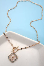 Load image into Gallery viewer, Necklace with a pendant on a white dish against a light blue background