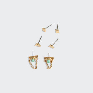 Gold earrings with turquoise stones on a light gray background