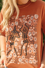 Load image into Gallery viewer, Person wearing an orange t-shirt with skeleton and floral design
