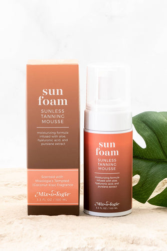 Sun foam sunless tanning mousse packaging with a green leaf on a light background