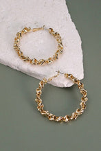 Load image into Gallery viewer, Gold hoop earrings on a stone surface with a gray background