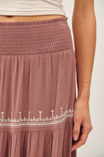 Load image into Gallery viewer, Close-up of a mauve skirt with white embroidery on a plain background