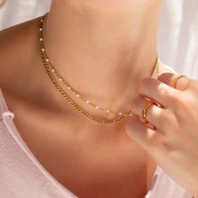 Load image into Gallery viewer, Gold chain necklace being adjusted on a person wearing a light pink top.