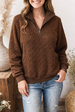 Load image into Gallery viewer, Woman wearing a brown cable knit sweater and blue jeans indoors.
