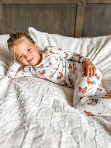 Child wearing a patterned onesie lying on a bed