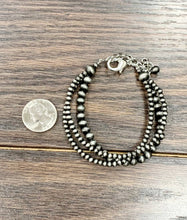 Load image into Gallery viewer, Beaded bracelet on a wooden surface with a coin for scale