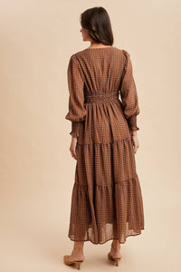 Woman wearing a brown patterned dress on a beige background