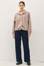 Load image into Gallery viewer, Person wearing a beige jacket and dark blue jeans against a white background