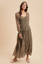 Load image into Gallery viewer, Woman wearing a long, patterned dress against a beige background