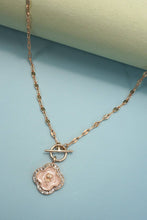 Load image into Gallery viewer, Gold necklace with a pendant on a light blue background