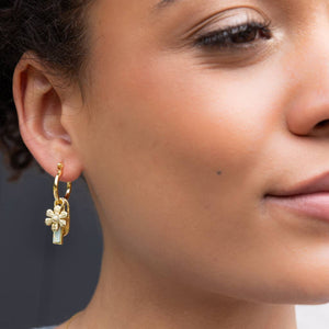 Close-up of a woman wearing gold earrings with a dark background